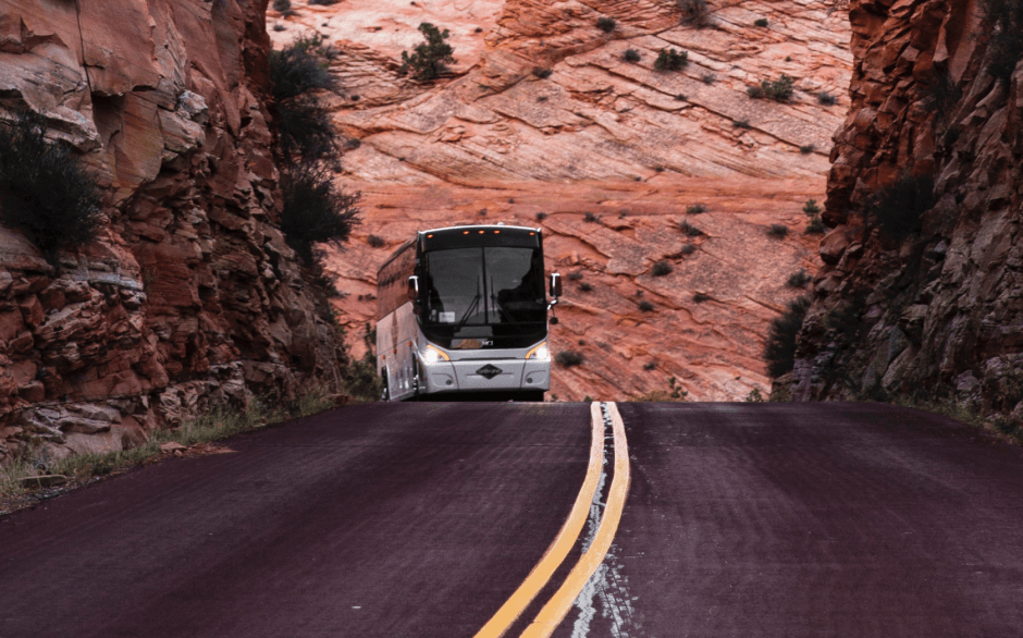 Charter bus driving through scenic canyon